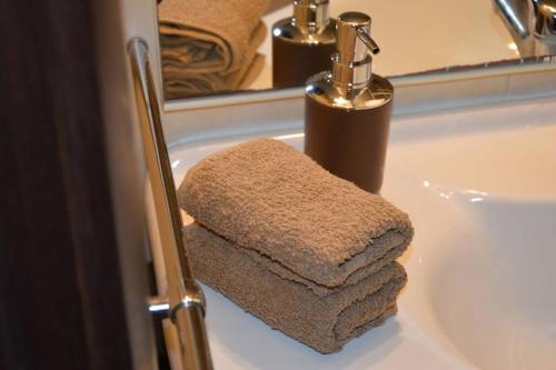 a towel dispenser sitting on a bathroom sink at Olimpia House - Central Station in Bari
