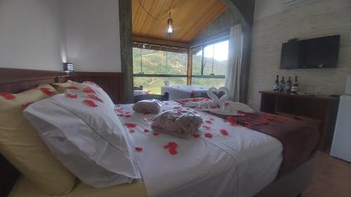 um quarto com uma cama com flores vermelhas em Refúgio Serra Negra em Serra Negra