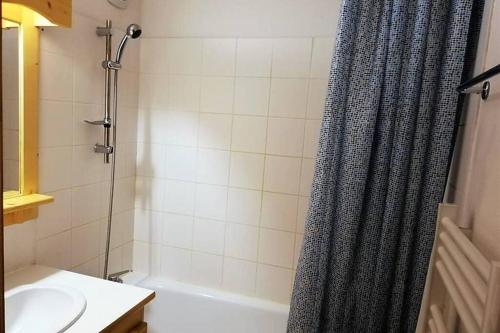 a bathroom with a shower curtain and a sink at Le Cottage des Sybelles in Saint-Sorlin-dʼArves