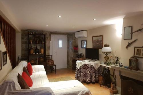 a living room with a white couch and a table at A casinha do beco in Gouveia