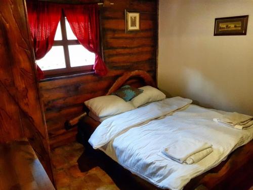 a small bed in a room with a window at Apartman Zelengora Dolina mira in Pale