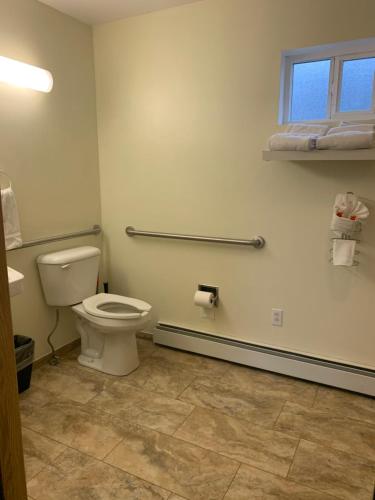 a bathroom with a toilet and a window at Marina Motel in Seward