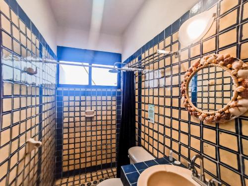 La salle de bains est pourvue de murs carrelés bleus et blancs et d'un miroir. dans l'établissement Hotel Tropicus Boutique, à Puerto Vallarta