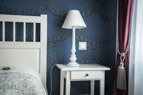 a lamp on a night stand next to a bed at Vilnius street apartment in Vilnius