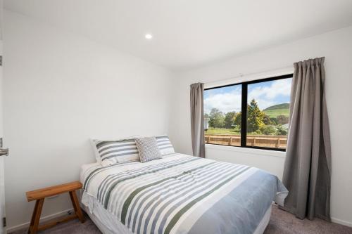a bedroom with a bed and a large window at Lake Days - Omori Holiday Home in Kuratau