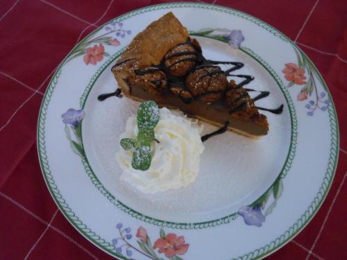 a plate with a piece of pie with whipped cream and broccoli at Agriturismo Cassinazza in Orsenigo