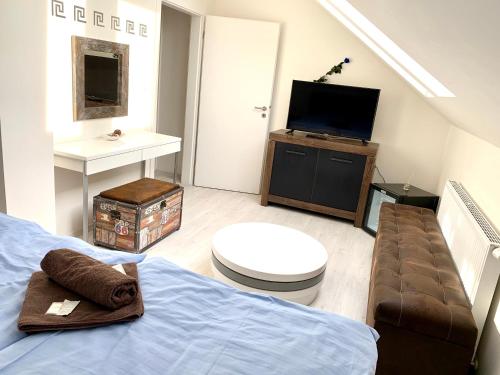 een slaapkamer met een bed en een tv en een bank bij Hotel Stará Pošta in Zdiby