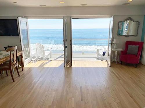 a living room filled with furniture and a view of the ocean at Malibu Private Beach Apartments in Malibu