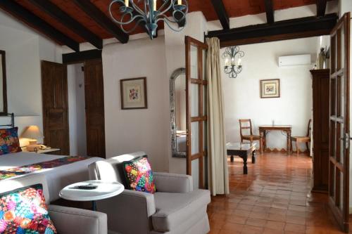 a living room with a bed and a dining room at Hotel Casa Rosada - Adults Only in San Miguel de Allende