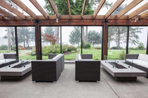 ein Wohnzimmer mit Sofas und vielen Fenstern in der Unterkunft Best Western Plus Tin Wis Resort in Tofino