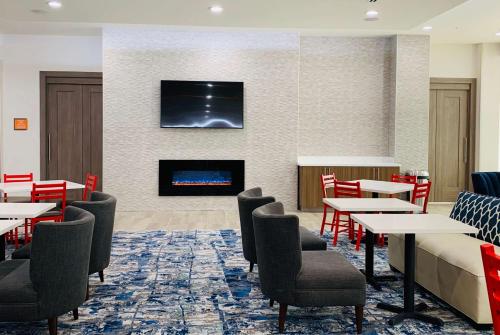 a restaurant with tables and chairs and a fireplace at La Quinta Inn & Suites by Wyndham - Red Oak TX IH-35E in Red Oak
