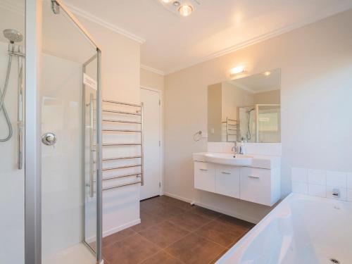 a bathroom with a shower and a sink at Lake on Scott - Cooks Beach Holiday Home in Cooks Beach