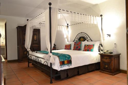 a bedroom with a canopy bed in a room at Hotel Casa Rosada - Adults Only in San Miguel de Allende