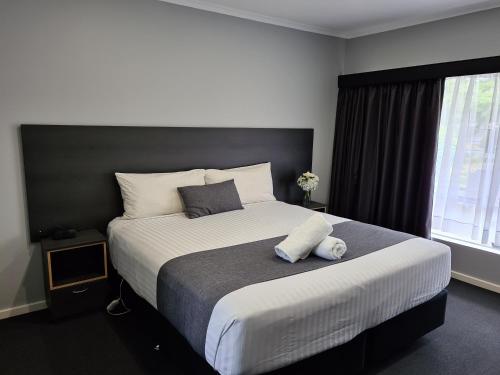 a bedroom with a large bed and a window at Beachway Motel in Ulverstone