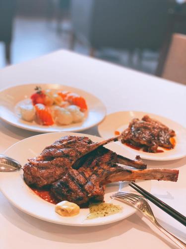 two plates of food with meat and vegetables on a table at Avonhotel Gunsan in Gunsan
