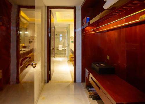 - un couloir menant à une salle de bains pourvue d'un lavabo dans l'établissement Kaixuanmen Hotel Shijiazhuang Yiling Health Center, à Shijiazhuang