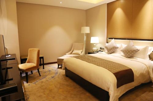 a hotel room with a large bed and a chair at Kaixuanmen Hotel Shijiazhuang Yiling Health Center in Shijiazhuang
