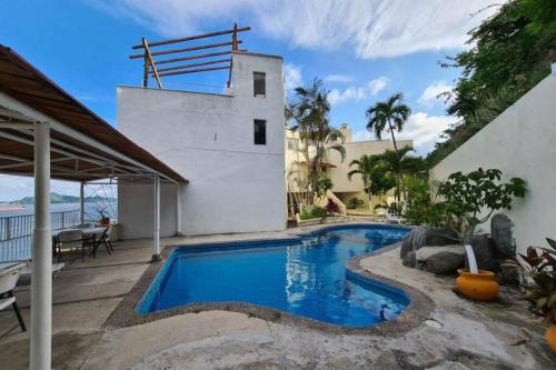a swimming pool in front of a house at SUITE 60 DELUX in Manzanillo