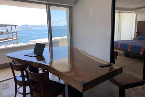 a wooden desk with a laptop on top of a bedroom at SUITE 60 DELUX in Manzanillo