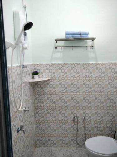 a bathroom with a shower with a toilet and a sink at Sacha Homestay in Baling