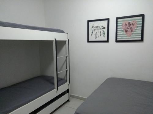 a bedroom with two bunk beds and two pictures on the wall at Gravatá Winterville Residence in Gravatá
