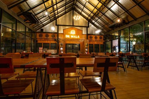 pusta restauracja z drewnianymi stołami i krzesłami w obiekcie De MALA w mieście Sukhothai