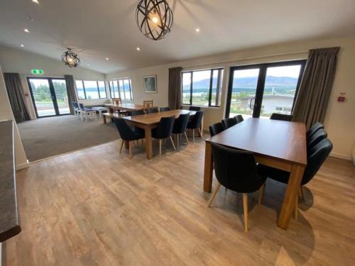 a dining room with tables and chairs and windows at Tekapo Ski Club Retreat in Lake Tekapo