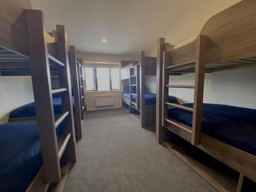 a room with four bunk beds with blue sheets at Tekapo Ski Club Retreat in Lake Tekapo