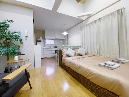 a bedroom with a large bed and a kitchen at nestay villa tokyo takanawa in Tokyo