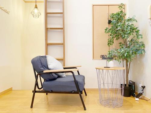 a chair in a living room with a plant at nestay villa tokyo takanawa in Tokyo