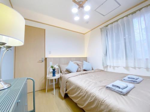 a bedroom with a bed with towels on it at nestay villa tokyo takanawa in Tokyo