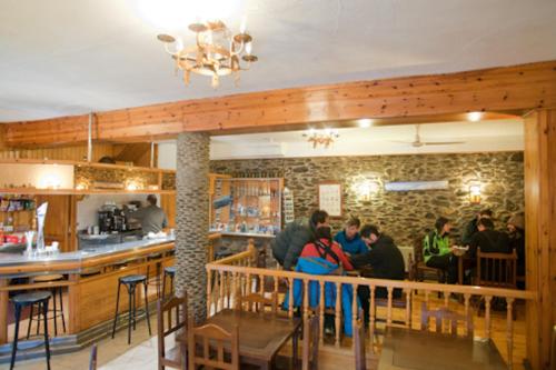un groupe de personnes assises au bar d'un restaurant dans l'établissement Hotel Llacs De Cardos, à Tavascan