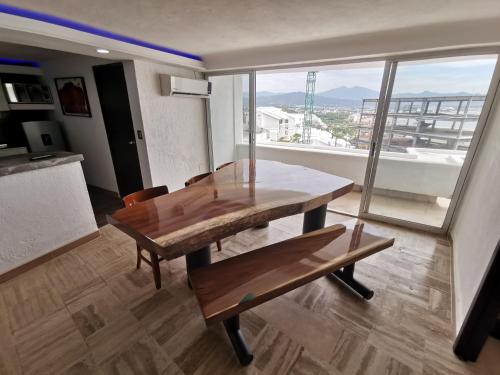a dining room with a wooden table and a bench at SUITE 60 DELUX in Manzanillo