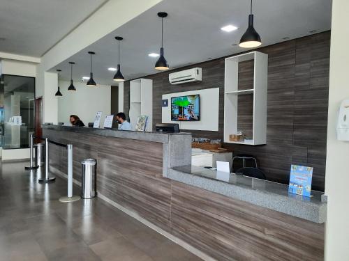 a lobby with a counter with two people at a reception at Flat Quartier Aldeia das Águas in Barra do Piraí