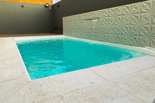 una piscina con agua azul en una habitación en Casa de Luxo na Praia - Sun Luxury Home, en Aracaju