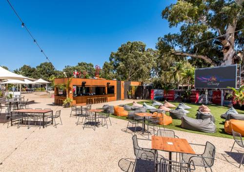 an outdoor amphitheater with tables and chairs and a screen at Marion Holiday Park in Adelaide