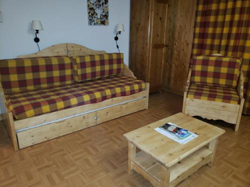 uma sala de estar com duas camas e uma mesa em Le Cottage des Sybelles em Saint-Sorlin-dʼArves