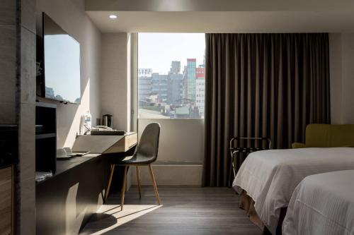a hotel room with a bed and a window at D D Hotel in Tainan