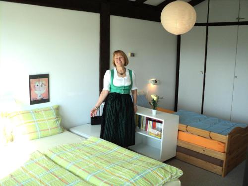 una mujer parada en un dormitorio con una cama en Ferienwohnung Teddy, en Siegsdorf