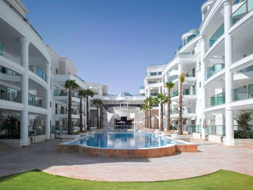 a large building with a swimming pool in front of it at Palmore Resort apartments in Eilat