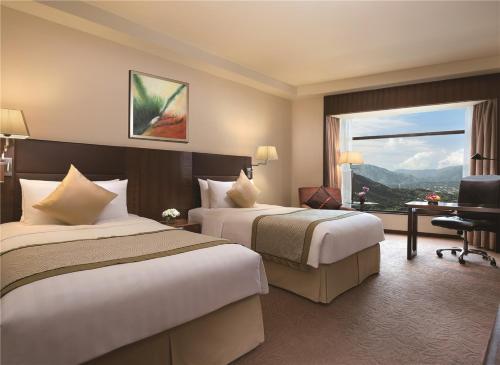 een hotelkamer met 2 bedden en een raam bij Shangri-La Shenzhen - Nearby Luohu Border, Outdoor Swimming Pool in Shenzhen