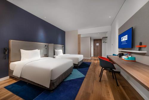 a hotel room with two beds and a desk at Holiday Inn Express Linyi North New District by IHG in Linyi