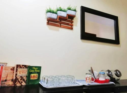 a table with a mirror and a shelf with books at John's Place, Kuching, Sarawak in Kuching