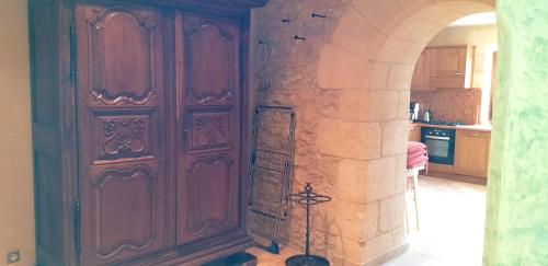 a kitchen with large wooden doors in a room at Maison conviviale à Saint-Cybranet avec piscine partagée in Saint-Cybranet