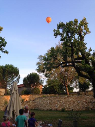a kite flying in the sky above a group of people at Maison conviviale à Saint-Cybranet avec piscine partagée in Saint-Cybranet