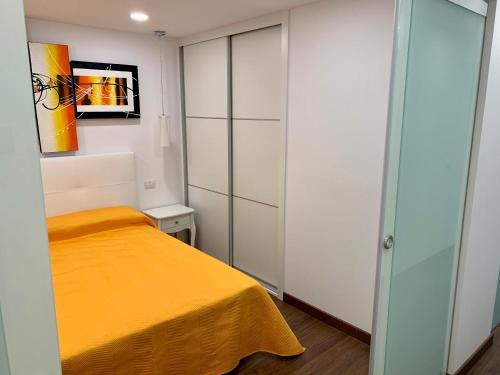 アデへにあるApartment Fañabe Mareverdeのベッドルーム(黄色のベッド1台、白いキャビネット付)