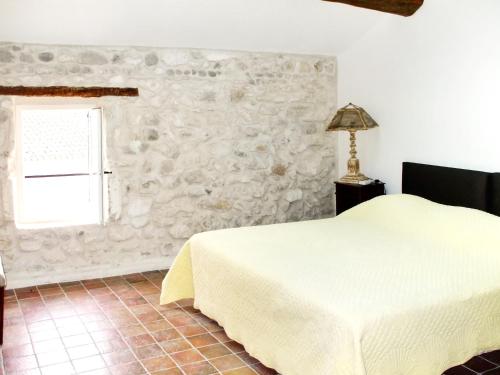 MollégèsにあるMaison de 4 chambres avec piscine privee jardin amenage et wifi a Mollegesの石壁のベッドルーム1室(ベッド1台付)