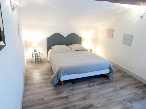 a bedroom with a large bed and two lamps at Maison spacieuse à Cabariot in Cabariot