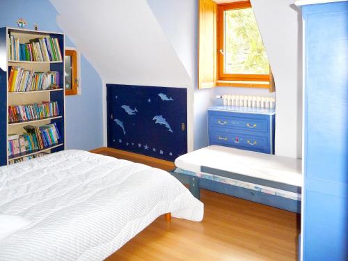 a bedroom with a bed and a book shelf at Maison de caractère à Plougrescant avec jardin et parking. in Plouguiel