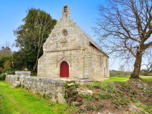 an old stone church with a red door at Maison de caractère à Plougrescant avec jardin et parking. in Plouguiel